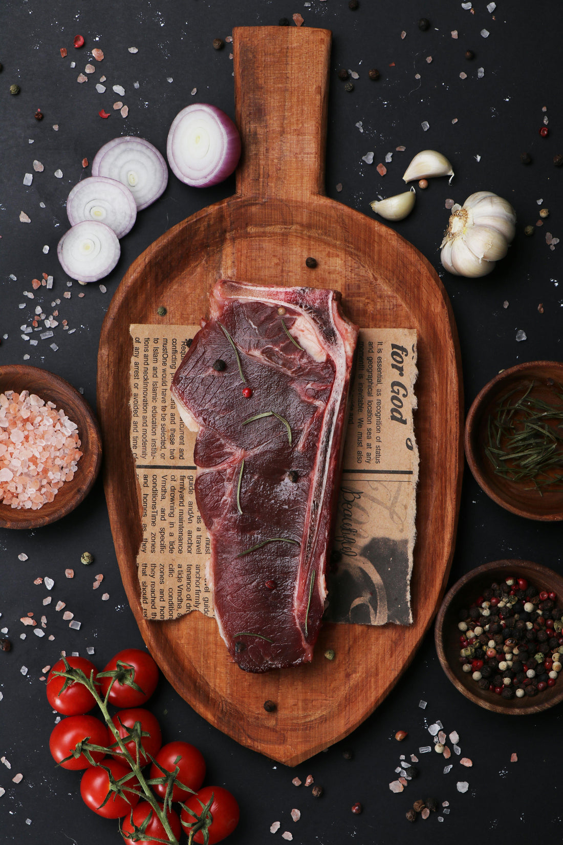 Raw steak on wooden board with Kampot pepper and salt, photo by Helia Ghaharian via Pexels.